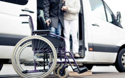 nurse helping senior man exit a van and get to his wheelchair